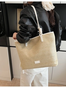 Minimalist straw tote bag with white leather straps and textured beige woven body