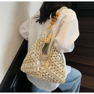 Detail of hand-woven off-white tote bag featuring distinctive wooden bead shoulder straps
