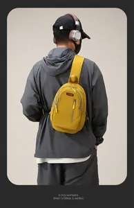 Close-up of yellow nylon crossbody bag featuring durable zipper and red brand logo