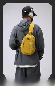 Close-up of yellow nylon crossbody bag featuring durable zipper and red brand logo