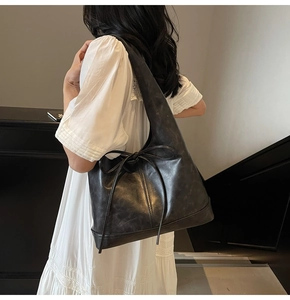Détail d'un grand sac en cuir noir avec un nœud élégant sur un escalier intérieur