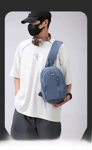 Close-up of blue nylon crossbody bag with multi-layer zipper pockets and logo plate