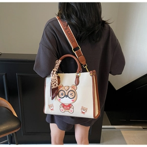 Detail view of large tote bag with bear print and stylish leopard scarf on hand model