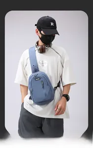 Blue crossbody chest bag with multi-layer zippers and textured nylon fabric on model
