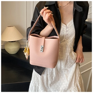 Close-up of pink bucket bag with quilted texture, silver lock and silk scarf detail