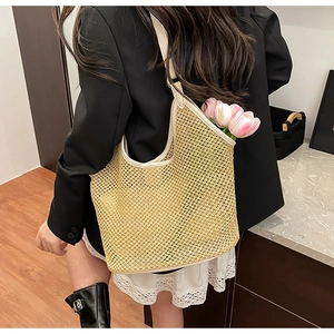 Détail du sac fourre-tout en paille tressée avec bordure en cuir beige et décor floral