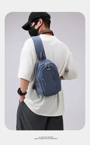 Rear view of deep blue nylon chest bag showing crossbody strap and multi-pocket design