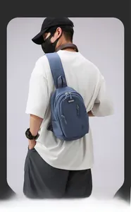Rear view of deep blue nylon chest bag showing crossbody strap and multi-pocket design