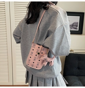 Pink cartoon crossbody bag with teddy bear print and cute dog charm shown on model