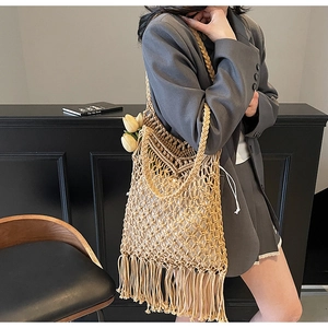 Detail of bohemian woven tote bag featuring long tassels and a white drawstring inner pouch