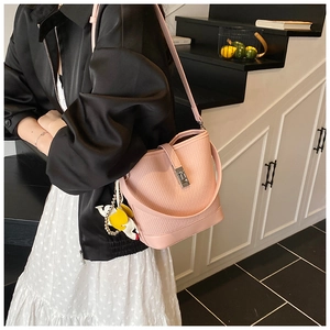 Pink woven bucket bag featuring a silver clasp and a cute unicorn charm accessory