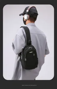 Close-up of the black nylon chest bag with MACHUGE logo and metallic zippers on the model