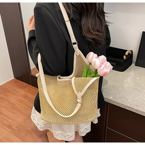 Détail du sac cabas en paille tressée avec anses crème et boucles en métal doré