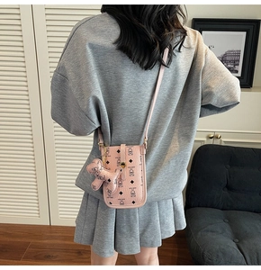 Detailed back view of pink teddy bear printed phone bag with cute dog charm