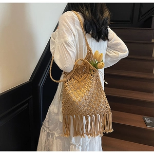 Macro detail of bohemian woven tote bag with long tassel fringe and hollow mesh texture