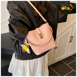 Pink bucket bag with textured leather finish, silver lock, and a cute yellow bird charm