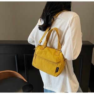 Side view of a bright yellow nylon crossbody bag on model for casual daily use