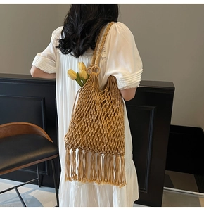 Detail of bohemian woven bucket bag with long tassels and hollow mesh texture