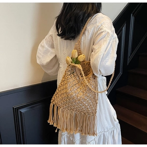 Detailed shot of bohemian hollow woven tote bag with long fringe and floral decoration