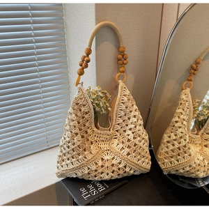Close-up of cream woven hobo bag with hollow crochet patterns and wooden bead handles