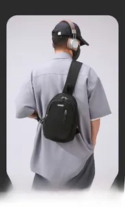 Detail of adjustable strap and nylon texture on black crossbody sling bag with logo