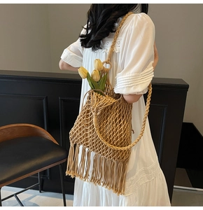Detail of hand-woven mesh shoulder bag featuring long fringe tassels in a boho style