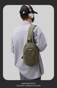 Detail of army green waterproof nylon crossbody bag showing zippers and brand logo