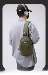 Detail of army green waterproof nylon crossbody bag showing zippers and brand logo