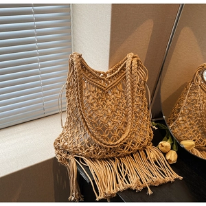 Detail of bohemian hand-woven tote bag with fringe tassels and drawstring liner