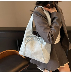 Gros plan d'un grand sac cabas en cuir PU bleu clair avec nœud et coutures élégantes