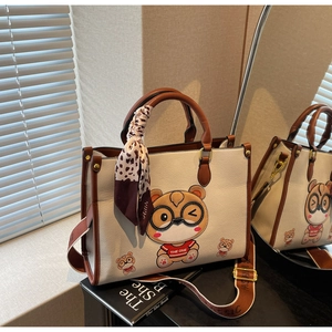 Detailed close-up of cute bear tote bag with wide leopard silk scarf and embroidered strap