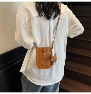 Brown PU leather phone bag with Lucky Bear pattern worn by a model on stairs