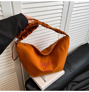 Detail of caramel canvas hobo bag with pleated handle and beyou Hemu artistic lettering