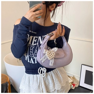 Close-up of lavender hobo bag with textured leather and decorative pearl bow charm