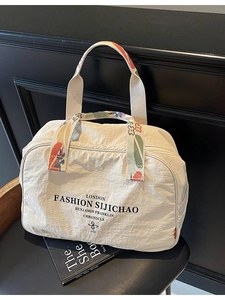 Large beige nylon travel bag with floral woven handles and spacious zipper closure
