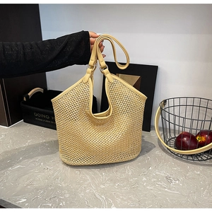 Détail d'un sac cabas d'été en paille avec texture tressée et anses en cuir synthétique