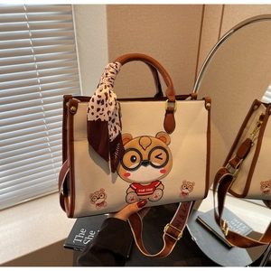 Detail of bear print tote bag with brown leopard scarf and striped crossbody strap