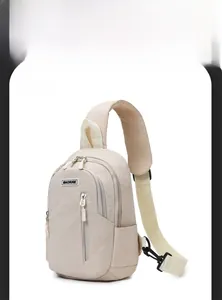 Detail of off-white crossbody bag featuring MACHUGE logo and dual zipper compartments