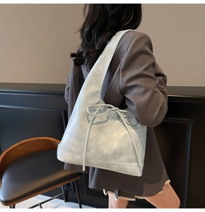 Grand sac à bandoulière bleu clair avec nœud coulissant porté par un mannequin de dos