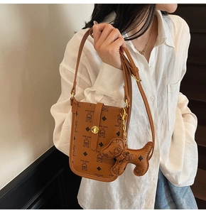 Detail of caramel brown mobile phone bag with bear pattern and dog leather charm