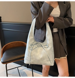 Détail du sac hobo bleu clair avec nœud coulissant et texture en similicuir vintage