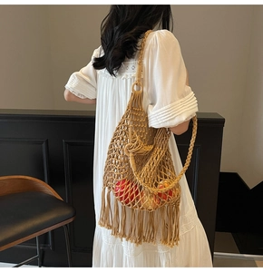 Detail of hand-woven hollow mesh tote bag with tassels and wooden ring handle