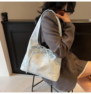 Grand sac fourre-tout bleu clair avec nœud décoratif porté à l'épaule pour le quotidien