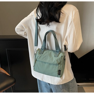Modèle portant un sac bandoulière en nylon vert clair avec sangle et style décontracté