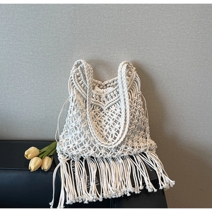 Close-up of bohemian macrame woven tote bag with fringe details and drawstring liner