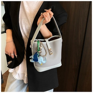 Light blue bucket bag featuring woven textures, silver twist lock, and elephant charm