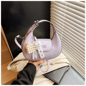 Detail view of lavender croissant bag with heart pearl charm and pleated leather texture