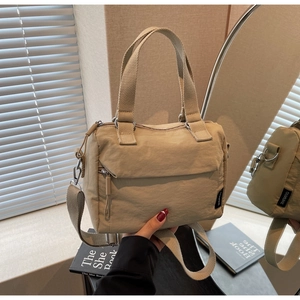Detail of light beige nylon Boston bag with woven handles and adjustable shoulder strap