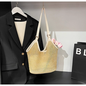 Gros plan d'un sac cabas en maille tissée beige avec bandoulières en cuir crème et tulipes