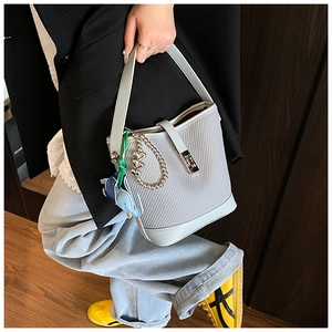 Detail of light blue mesh bucket bag with a cute elephant charm and metal buckle